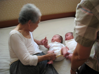 The two-month old twins on their great-grandmother’s bed