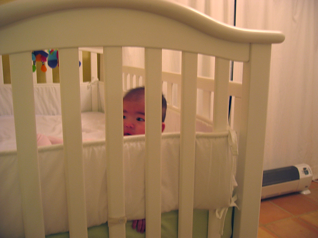 Eleanor Looking over the Crib Bumper